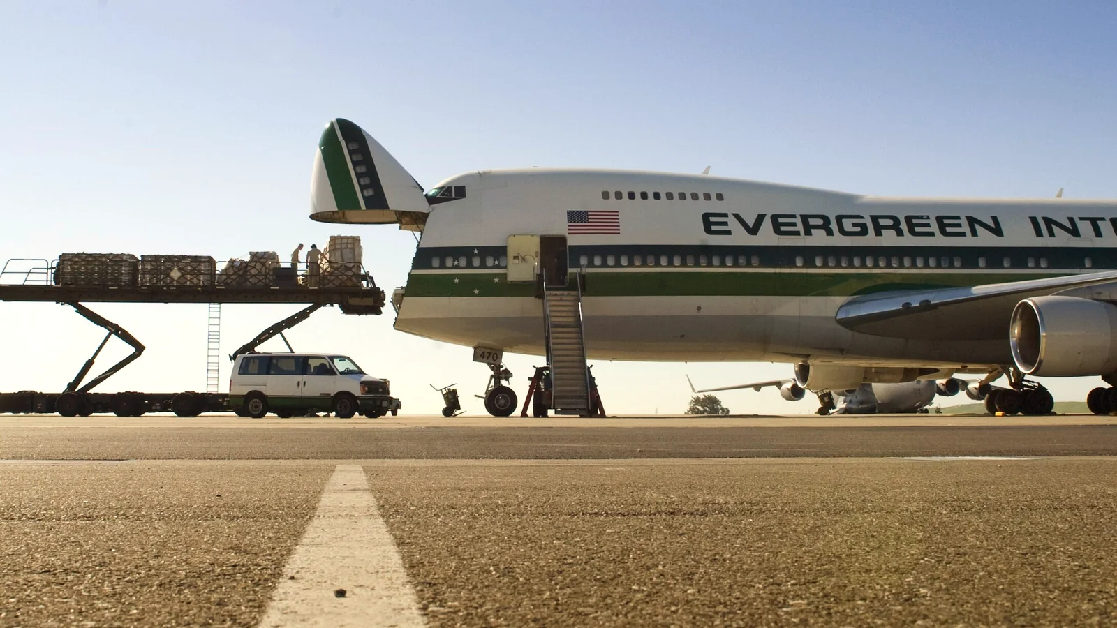 Boeing 747 freighter on the apron with a main-deck loader carrying cargo pallets