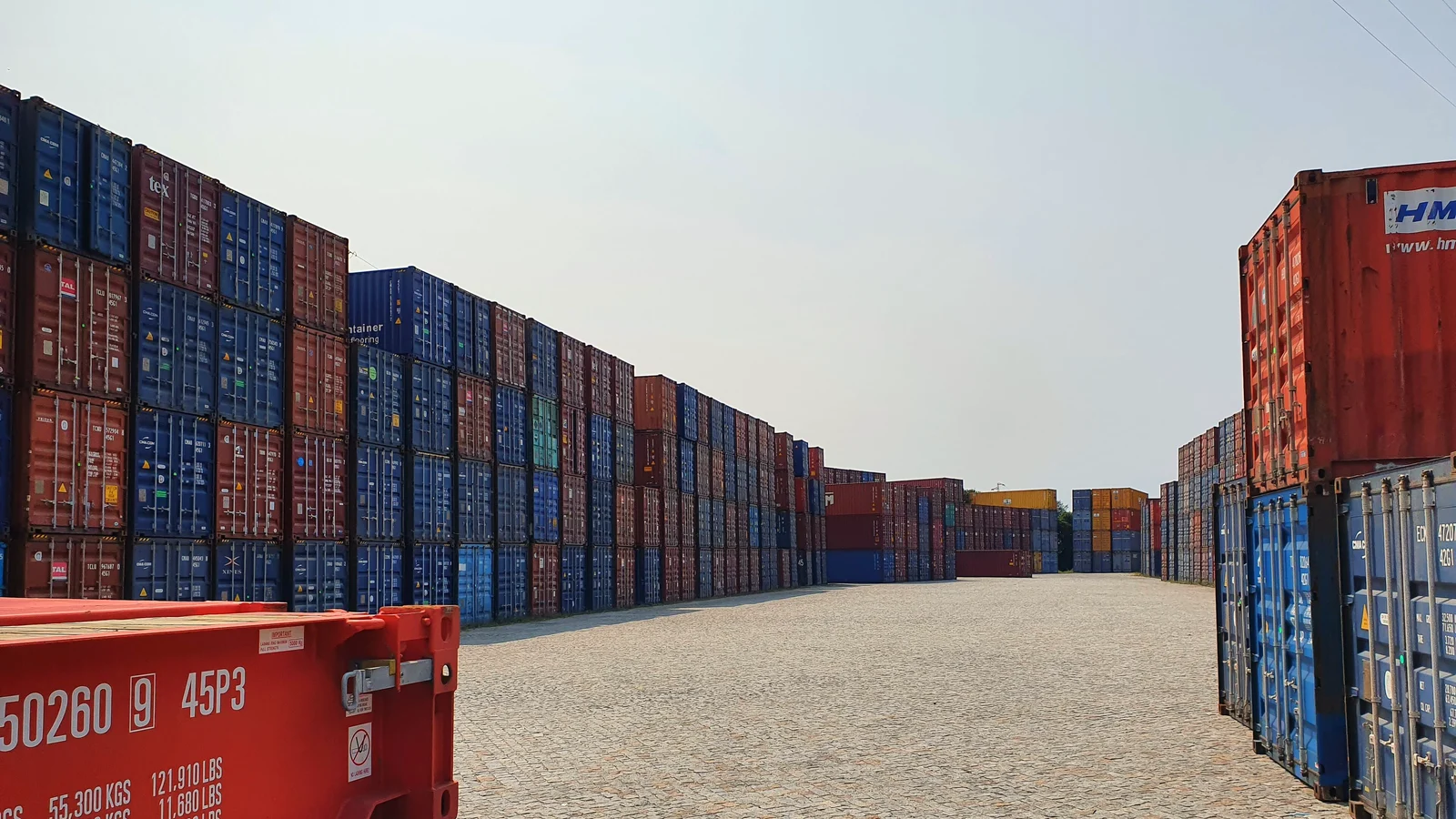 Long rows of stacked empty shipping containers in a container depot