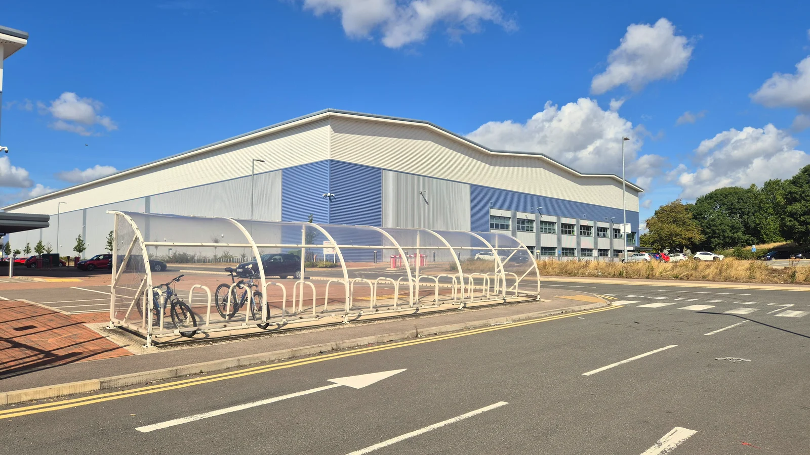 Large white and blue logistics warehouse under a blue sky