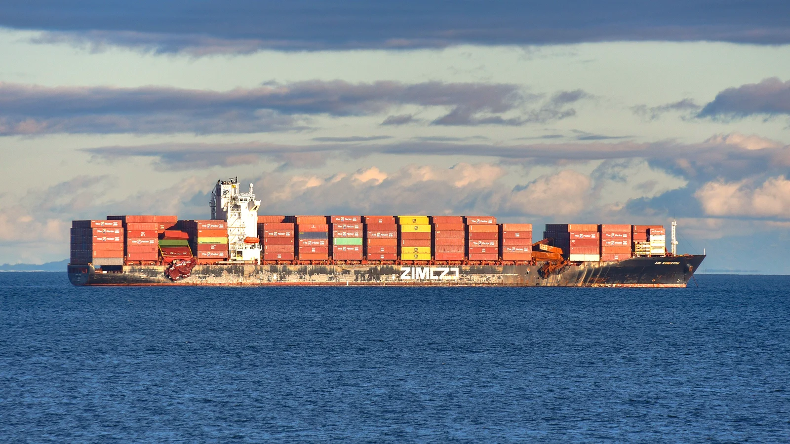 Fully loaded ZIM container ship at sea under a wide sky