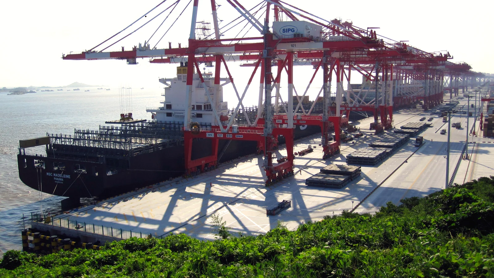Container ship at the long quay of Yangshan Deep-Water Port near Shanghai under gantry cranes